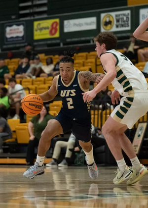 Jordan Rice playing basketball in blue UIS uniform in Missouri S&T gym
