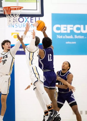 Isaiah Davis goes up for a block in men's basketball