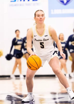 Julia Mingus playing basketball at UIS in white uniform