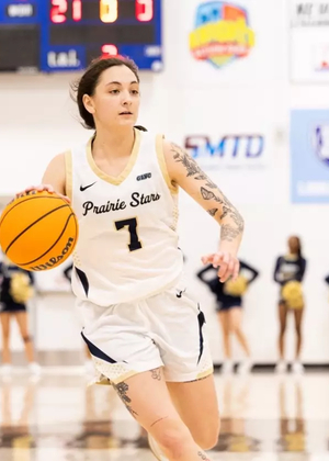 Kennedy Osterman playing basketball in white UIS uniform