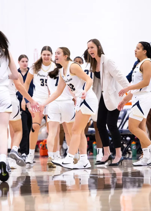 UIS WBB team celebrating on court