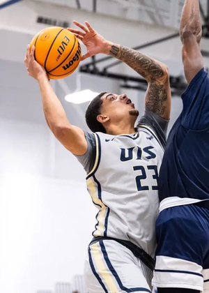 Tye Banks playing basketball in gray UIS uniform