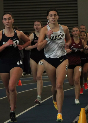 Mackenzie Billard running indoor track in white UIS uniform