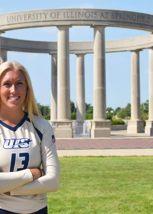 Alyssa Hasler poses in front of UIS Colonnade in gold volleyball uniform