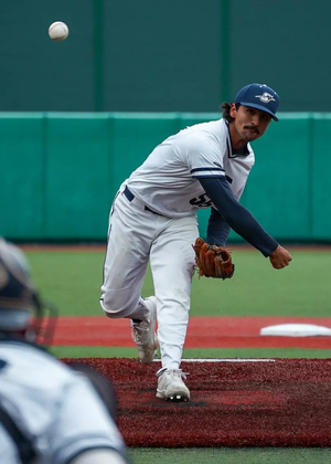 Esteban Hernandez pitching in white UIS uniform