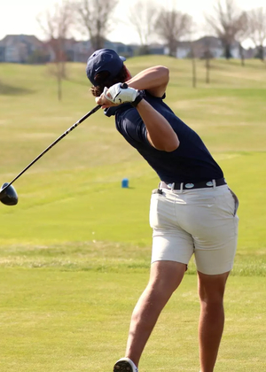 Julien Babineau playing golf in blue UIS polo