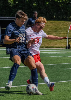 Josh Mensching playing soccer in blue UIS uniform
