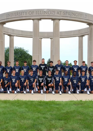 Team photo of UIS mens soccer team in blue uniforms, along with staff