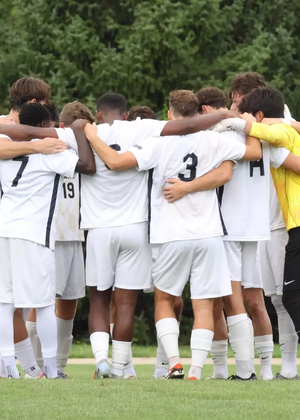 Men's Soccer Huddle on field pre-game, UIS players in white and yellow jerseys