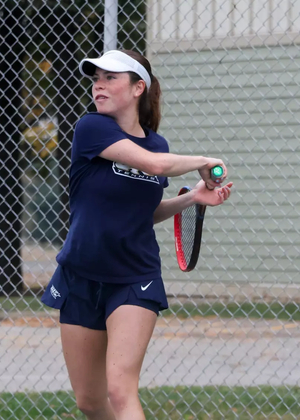 Maria Garcia Gama playing tennis in blue UIS uniform