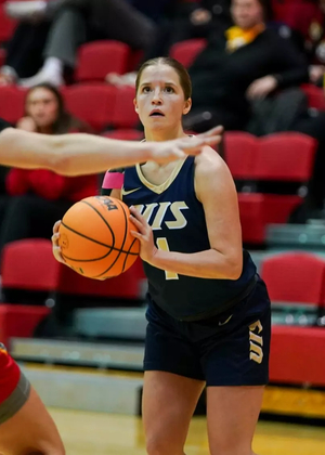 Brynn Tabeling playing basketball in blue UIS uniform