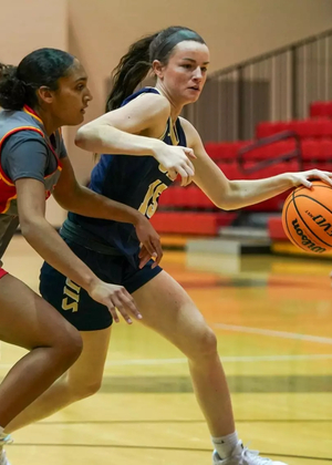Molly Knight playing basketball in blue UIS uniform
