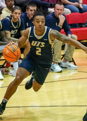 Jordan Rice playing basketball in blue UIS uniform