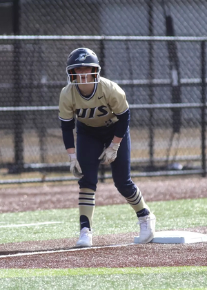 Rebecca Neupauer base running in gold UIS uniform