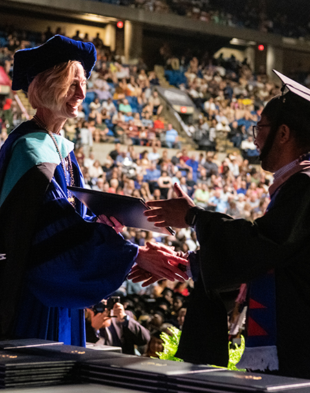 Chancellor Gooch shaking grads hand