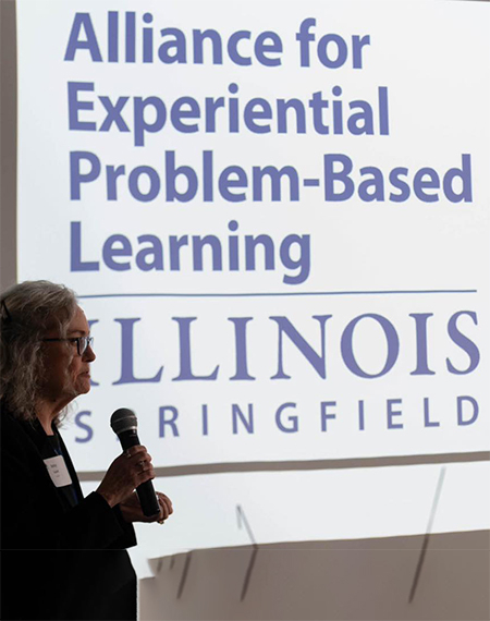 Alliance for Experiential Problem-Based Learning logo on a screen with Betsy Goulet talking