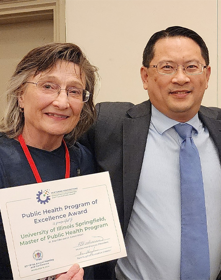 Lenore Killam and Brian Chen hold a Public Health Program of Excellence Award from the Illinois Public Health Association.