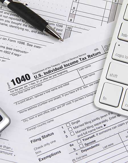 1040 tax form with a pen and computer keyboard.