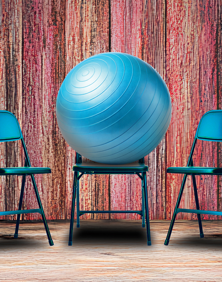 Blue exercise ball on chair between two folding chairs, wood-textured background.