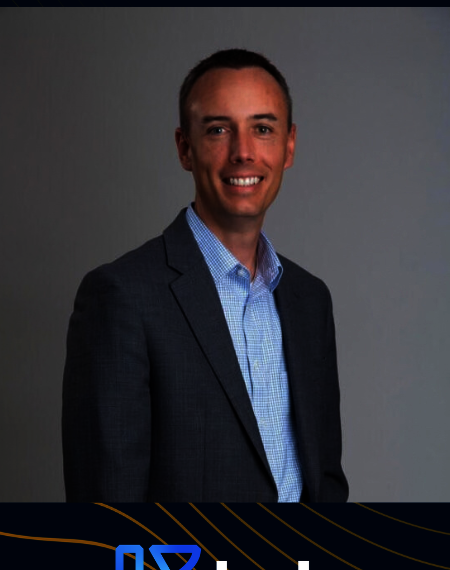 Smiling man in suit against gray background, with a blue logo and "keb" text below.