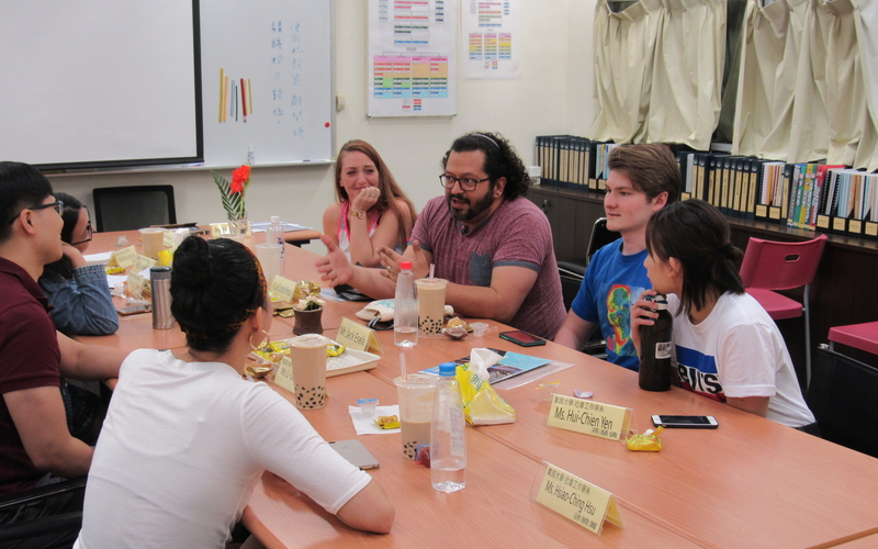 Students sit at a table in a meeting room