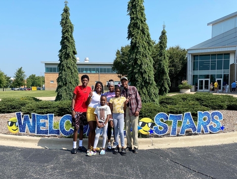 Family on Move-In Day in front of TRAC posing with a welcome stars sign