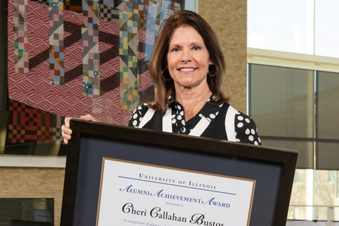 Cheri Bustos holding her Alumni Achievement award