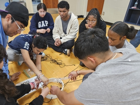 Multiple students solving a team building project together.