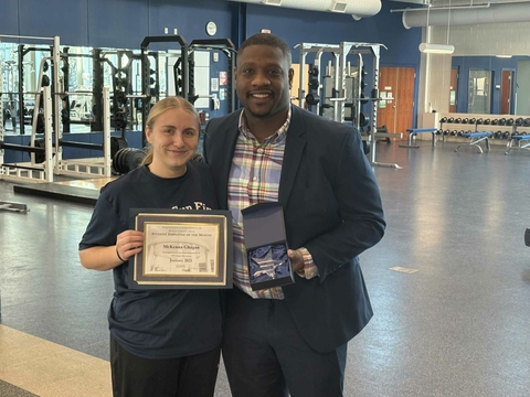 McKenna Ghagan holding up her award with Dr. Clark