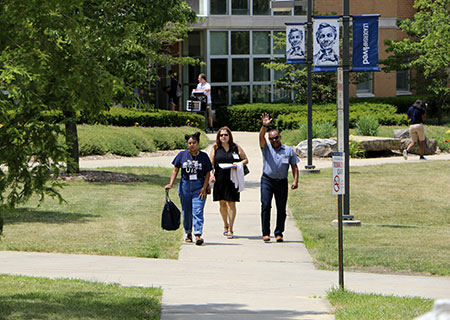 Two parents and their student walking on campus