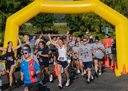 UIS students running over the finish line of a running event