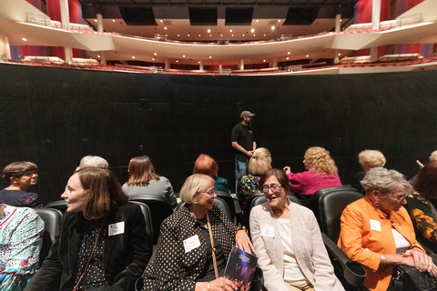 a group of women ride the stage lift down in Sangamon Auditorium