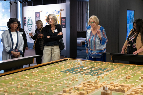 four women look at a model of downtown Springfield from when Lincoln lived there