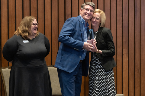 Bryan Rives hugs Chancellor Gooch as he accepts his award