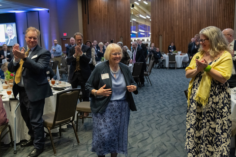 attendees applaud while Mary makes her way to the stage