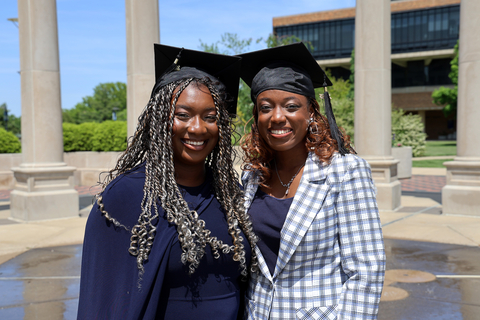 female graduates in front of colonnade