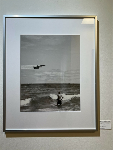 a man watching Blue Angels jets over a body of water