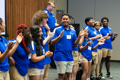 Orientation leaders on stage chanting.