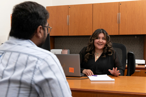 an advisor at her computer with a student sitting next to her