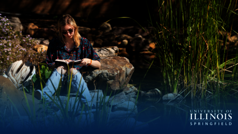 Student reading by the Koi Pond.