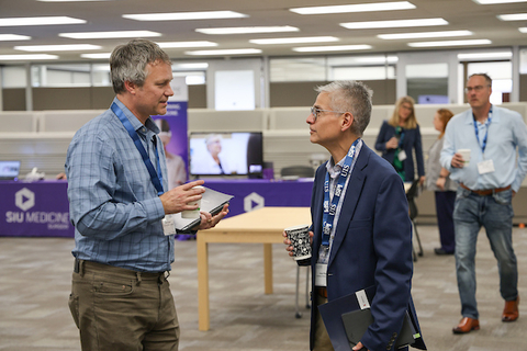 Two professors talking at inaugural Founders Day