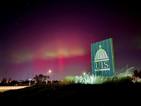 Northern lights are visible behind the UIS entrance marker on 11th street.