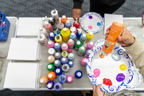 Students put paint on a paper plate as a part of relaxation craft during finals week.