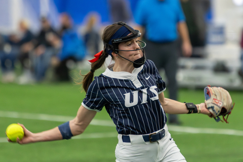 UIS softball player in motion, ready to throw, inside the Scheels Sports Park Dome