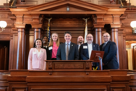 Group of people smiling in chambers at the state capitol