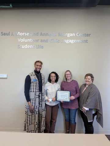 Jazel Ware-Grant receiving award from three professional staff members.