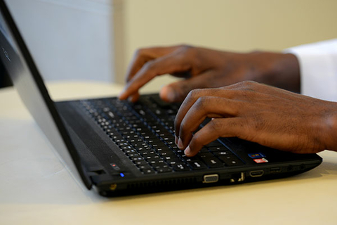 Typing on a laptop with black keys