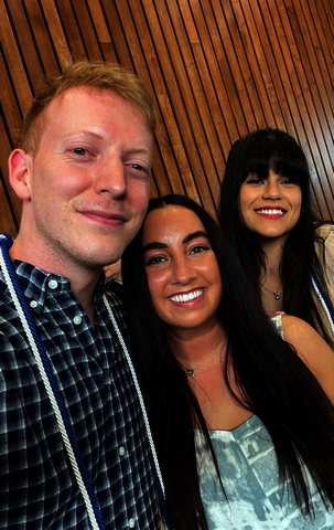 Christopher smiling with two friends.