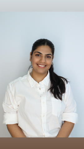 student posed in front of a light blue background with white shirt.