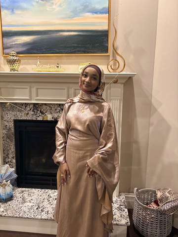 students posed in front of a fireplace with a gold dress.